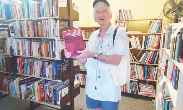 Author and university lecturer Bill Murray finds a copy of his own book at the Nhill Book Fair.