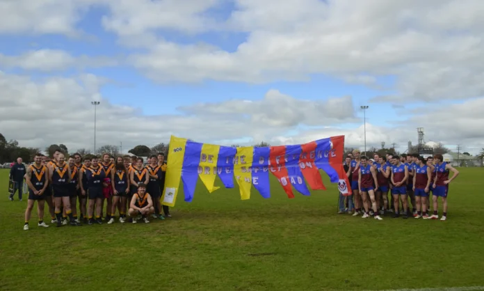 Nhill Tigers and Horsham Demons Reserve players with the banner