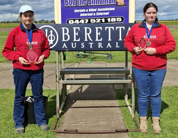 Evie and Caitlin with their medals and trophies.